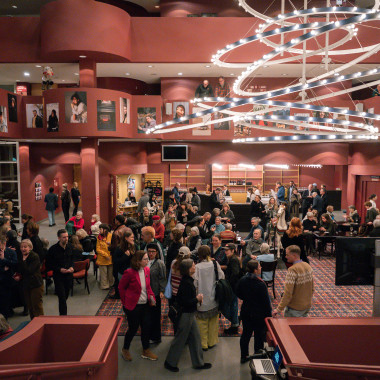 Das Foyer des Schauspiel Hannover während der Festivaleröffnung, mit zahlreichen Besucher*innen die im Raum verteilt stehen und sich unterhalten.