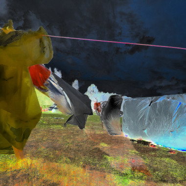 Farblich bearbeitete, Bild einer Outdoor-Installation. Stoffbahnen in Gelb, Schwarz und Silber hängen an einer Leine über einer Wiese. Der Himmel erscheint dunkelblau fast schwarz, der Boden leuchtend gelb und rot verfärbt.