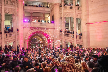 Blick in die volle Halle des Neuen Rathauses Hannover, Konfetti fällt in die Menge, während Publikum auf mehreren Ebenen feiert.